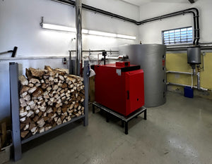 IBC Holzvergaserkessel GK-7k-öko im Heizraum neben gestapeltem Holz und Heiztank für nachhaltige Energie💧🔥